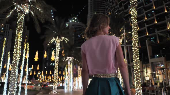 A Young Woman is Walking Along the Evening Dubai