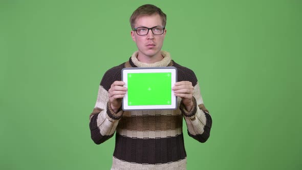 Young Handsome Man Thinking While Showing Digital Tablet