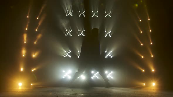 Silhouette of a Talented Young Hip Hop Dancer. Hip Hop Street Dance on a Stage in Dark Studio with