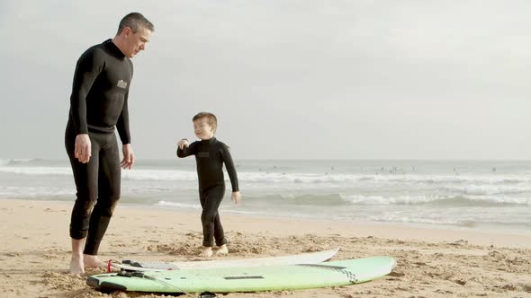 Father and Little Son Lying on Surfboard