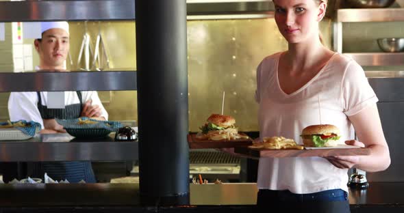 Woman holding burger and french fries at restaurant