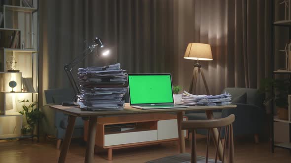 Green Screen Laptop With Documents On The Table At Home