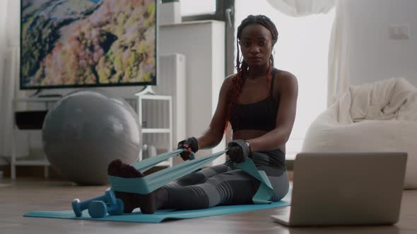 Fit Black Woman in Sportswear Looking at Online Workout on Laptop
