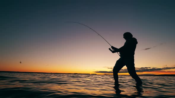 Fishing Rod Is Getting Reeled Up By a Male Fisher