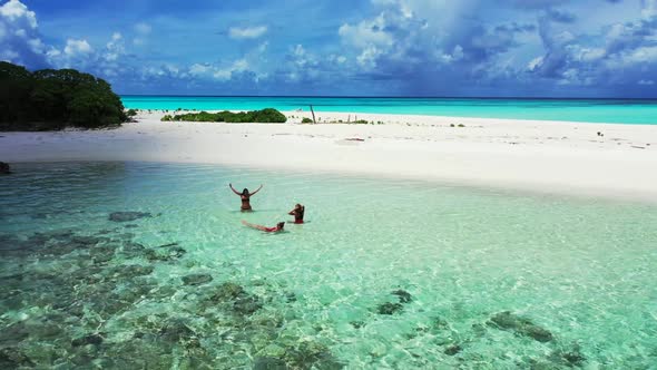 Women tan on relaxing tourist beach holiday by clear lagoon with white sand background of the Maldiv