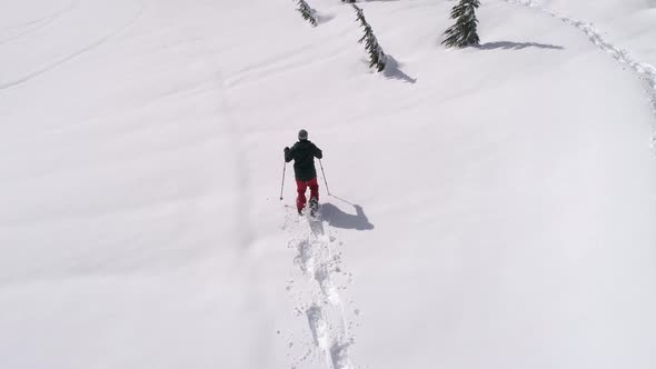 Drone Following Man Breaking Snowshoe Trail In Fresh Deep Powder Snow