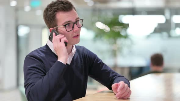 Cheerful Young Businessman Talking on Smartphone