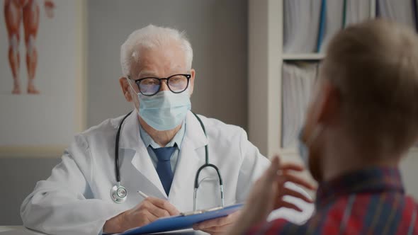 Senior Doctor in Mask Seeing Patient Who Is Coughing.