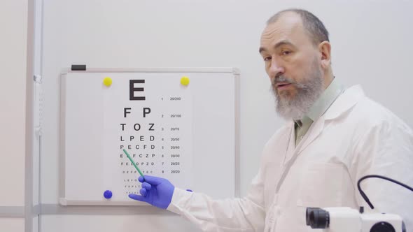 Senior Optician Pointing at Eyechart during Vision Test