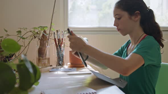 Teenage girl drawing using a tablet computer and an electronic pen