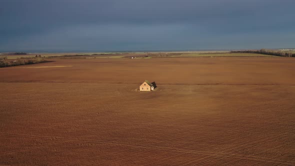 lonely standing house in the middle of a field top view from a drone.