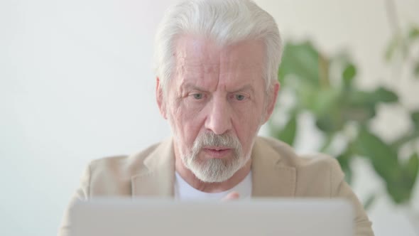 Close Up of Old Man Talking on Video Call on Laptop in Office