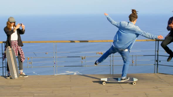 Rear view of young male skateboarder riding on skateboard at observation point 4k