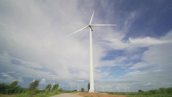 Wind turbines or windmills farm field and mountain hill with blue sky