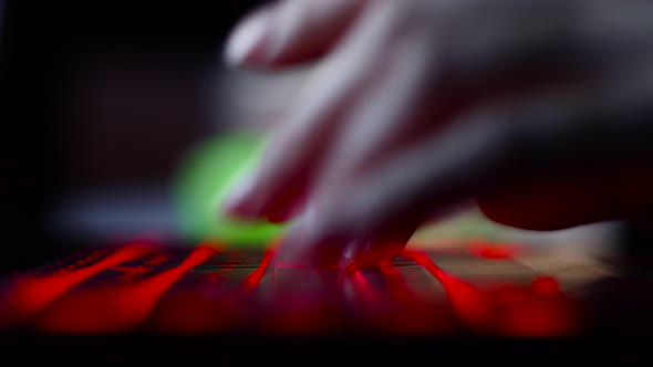 Hacker Girl's Hand Typing on Keyboard with Red Backlight