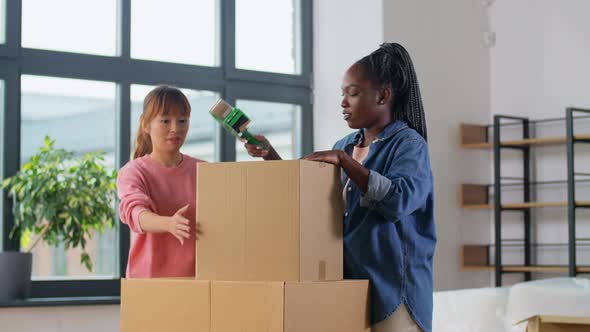 Women with Adhesive Tape Packing Boxes at Home