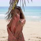 Cheerful Ethnic Female Standing Near Palm on Beach - VideoHive Item for Sale