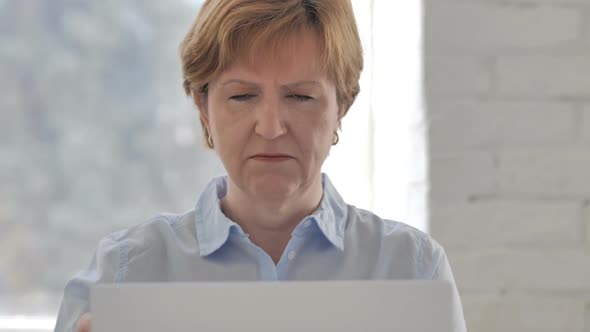 Thumbs Down By Old Woman Looking at Camera at Work