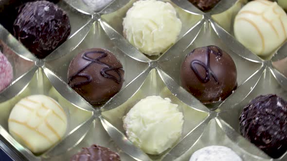 Box of chocolate bonbon rotating. Close up on mixed chocolates.