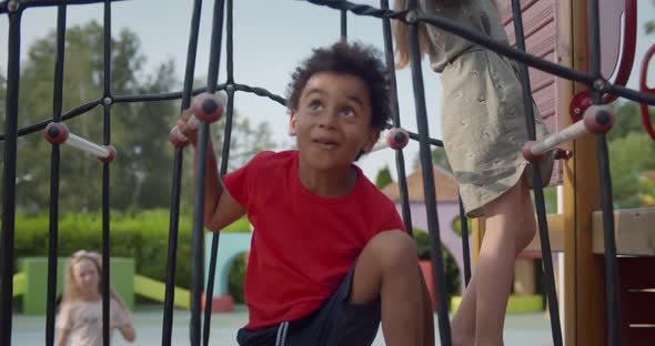 Portrait of African Child Climbing on Rope Ladder on Playground