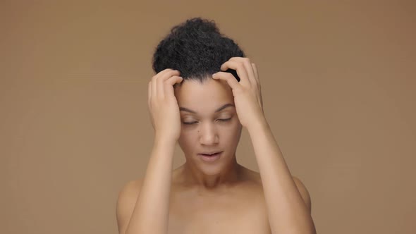 Beauty Portrait of Young African American Woman Looking in Mirror Touching Face and Correcting Hair