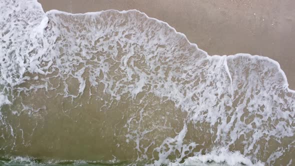 Sea water wave hit the sandy beach
