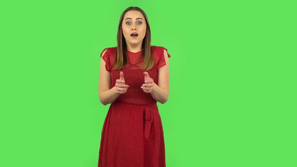 Tender Girl in Red Dress Is Looking at Camera with Anticipation, Then Very Upset. Green Screen