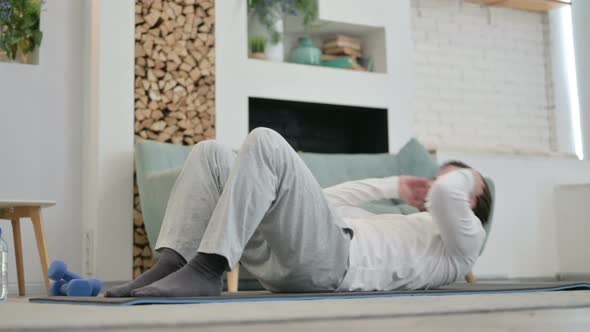 Young Man Doing Workout on Yoga Mat at Home