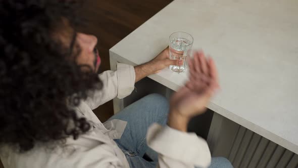 Muslim Man Takes Pill Drinking Water at Table in Morning