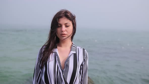 Young Attractive Woman Near the Ocean on a Summer Day