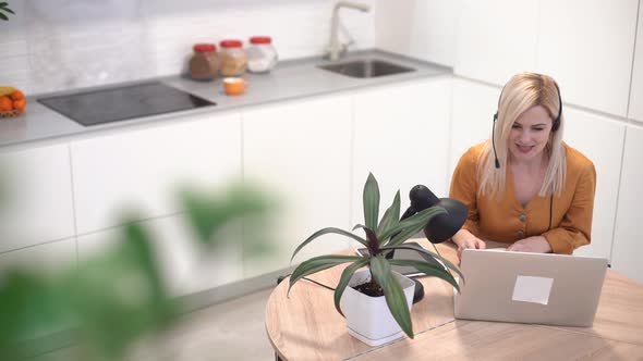 Woman Working with Laptop in Bright Kitchen