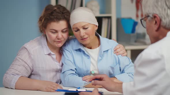 Senior Cancer Woman with Daughter Visiting Doctor in Hospital