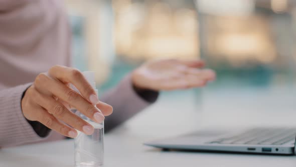 Out of Focus Blurred Background Unrecognizable Woman Sits at Desk Wiping Hands with Antibacterial