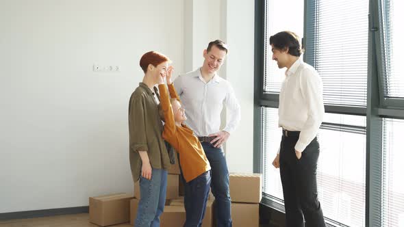 Handsome Man Shaking Hands with Real Estate Agent in New Apartment