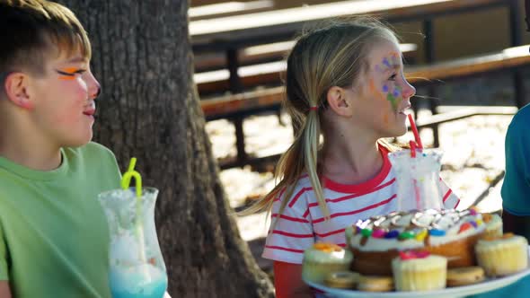 Kids having sweet food and drinks in the playground