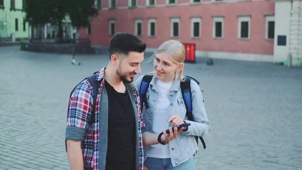 Happy Tourists with Smartphone Finding Beautiful Place in the Downtown of Old European City