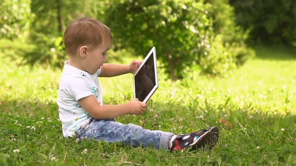 Happy Boy Playing in Tablet Outdoors