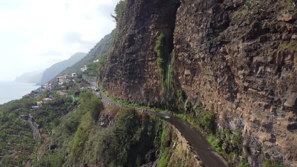 A waterfall in the middle of the road in Madeira. Shot on DJI.