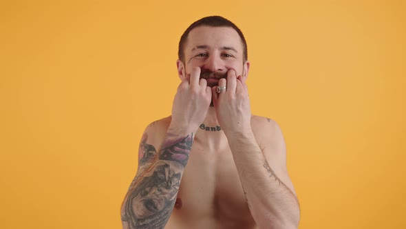 Shirtless European Tattooed Guy in His 30s Touching and Playing with His Brown Bushy Mustache While