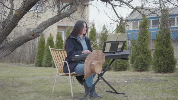 Talented Beautiful Brunette Girl Passionate About Playing Synthesizer and Sings