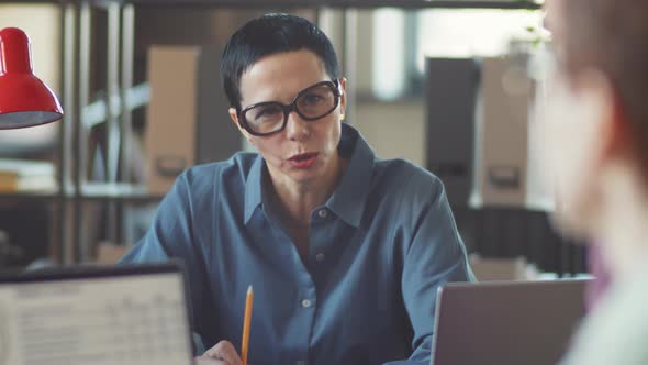 Businesswoman Talking with Coworkers at Office Meeting