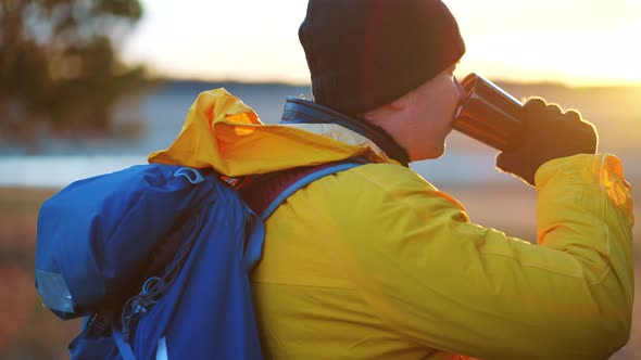 Hiker Young Tourist Enjoying Nature Drinking Hot Tea at Sunset