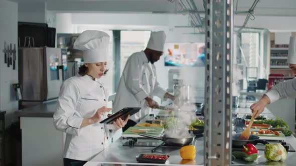 Authentic Chef Looking at Food Recipe on Digital Tablet Screen