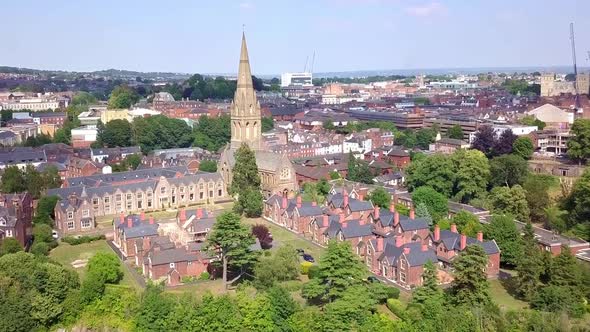 Aerial push toward St Leonards church spire in the Exeter, England, cityscape