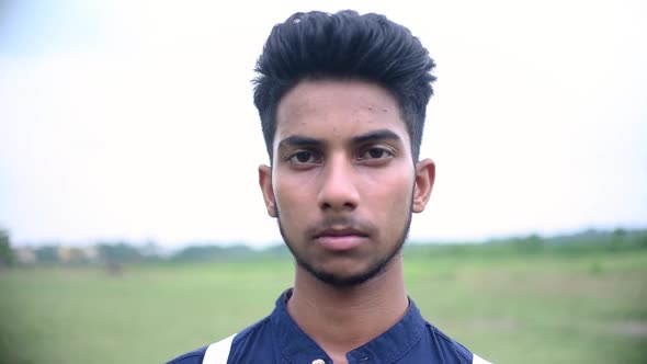 Teenager confident boy looks at camera in serious mood, closeup portrait