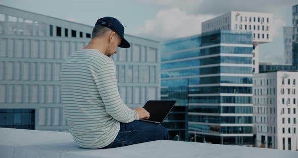 Hipster Man Work on Laptop in Business District