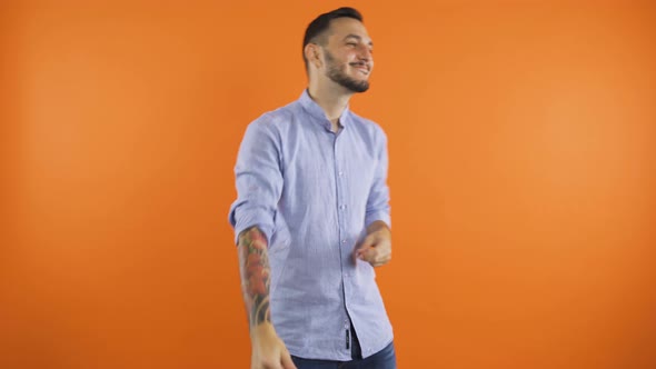 Young Smiling Man in Shirt Dancing Happily Snapping with Fingers and Waving Arms. Happy, Positive