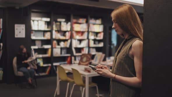 Young Woman Using Smartphone in Library