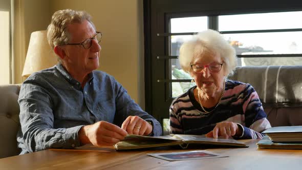 Active senior couple looking at photo album 4k
