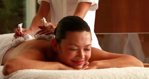 Gorgeous woman getting a massage with herbal compresses